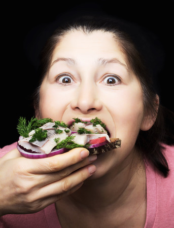 Woman chef offers a dish of smoked mackerel on the dish with vegetablesの写真素材