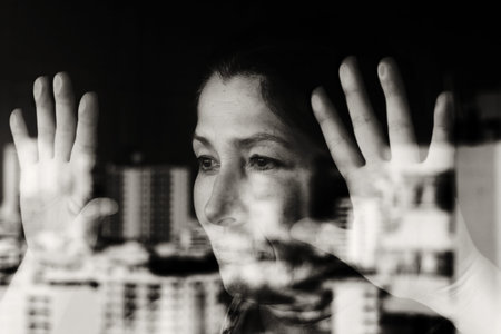 Beautiful 50 years old woman looking through the window