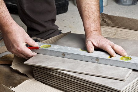 Renovation - Man construction worker laying floor tileの写真素材