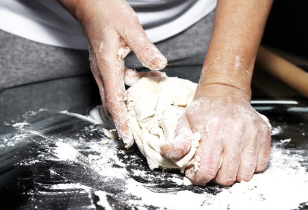 Making dough by female hands on glass table backgroundの写真素材