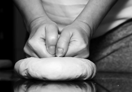 Making dough by female hands on glass table background