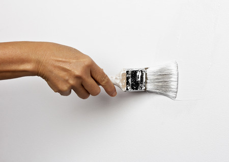 Hand paints the white wall brushの写真素材
