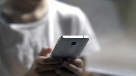 boy uses the phone, teenager hands texting on smartphone, close upの写真素材