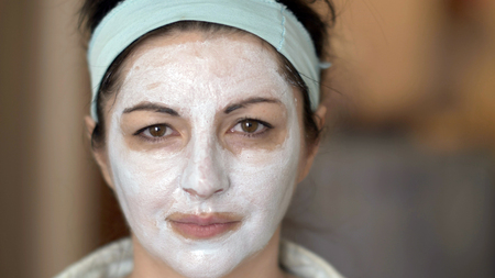 portrait of a woman with a cosmetic mask put on her face, a mask for rejuvenating the skin of her faceの写真素材