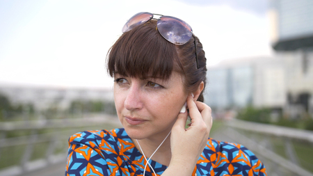 Woman Uses a Smartphone Listening to Musicの写真素材