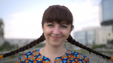 portrait of a woman with braids on her head, looking at the camera and smilingの写真素材