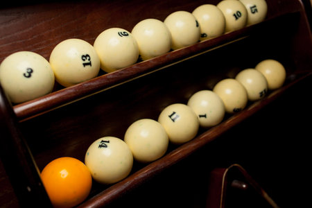 Balls for pool billiards on the shelf, billiard balls for American billiards, balls for Russian billiards, colored or white balls for billiards on a wooden background. Close-up photo. Soft focus.の写真素材