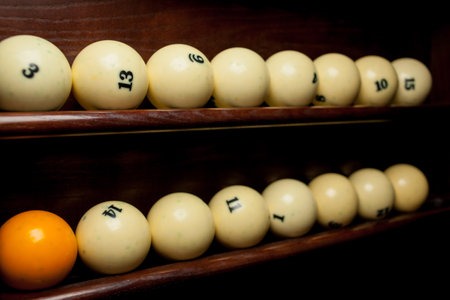 Balls for pool billiards on the shelf, billiard balls for American billiards, balls for Russian billiards, colored or white balls for billiards on a wooden background. Close-up photo. Soft focus.の写真素材