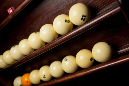 Balls for pool billiards on the shelf, billiard balls for American billiards, balls for Russian billiards, colored or white balls for billiards on a wooden background. Close-up photo. Soft focus.の写真素材