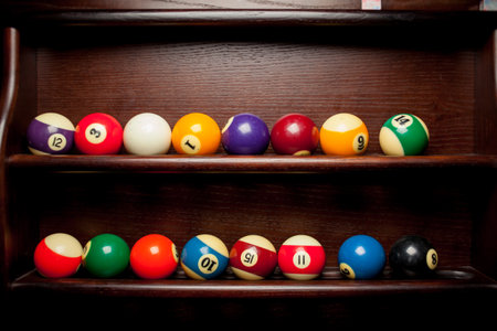 Balls for pool billiards on the shelf, billiard balls for American billiards, balls for Russian billiards, colored or white balls for billiards on a wooden background. Close-up photo. Soft focus.の写真素材