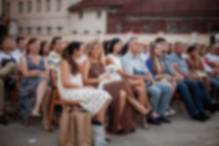 People are watching a concert of classical music. blurred young and adult women and men and other people watching listening to concert of classical band in daylight outdoor enviroment.の写真素材