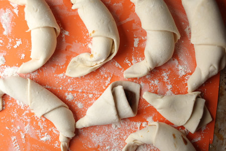 Producing classic croissants. Crescent rolls before baking. croissants on a tray. French Pastry goods, bakery. Dough for croissants. Preparation of croissants.の写真素材