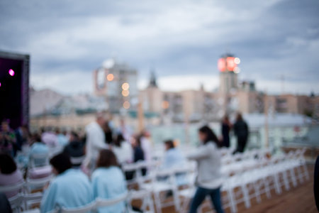 People are watching a concert of classical music. blurred young and adult women and men and other...