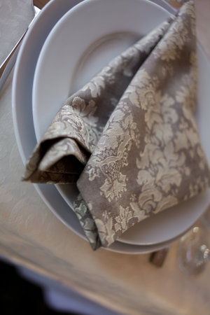 Classic design of the table. Table setting: brown napkin, knife and fork, wine glasses. served for dinner in cozy restaurant. Laid table in an elegant restaurant with some wine glasses. soft focusの写真素材