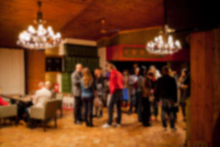 People rest in an ethnic, Mexican restaurant. Blurred photo. blur photo of restaurant with long table dinner and chair along it with bokeh light with yellow tone colorの写真素材