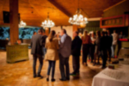 People rest in an ethnic, Mexican restaurant. Blurred photo. blur photo of restaurant with long table dinner and chair along it with bokeh light with yellow tone colorの写真素材