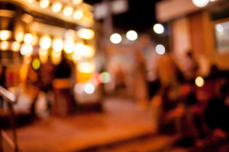 People rest in an ethnic, Mexican restaurant. Blurred photo. blur photo of restaurant with long table dinner and chair along it with bokeh light with yellow tone colorの写真素材