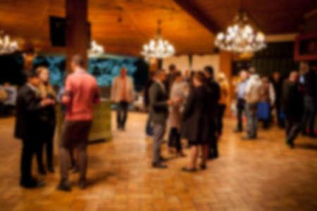People rest in an ethnic, Mexican restaurant. Blurred photo. blur photo of restaurant with long table dinner and chair along it with bokeh light with yellow tone colorの写真素材