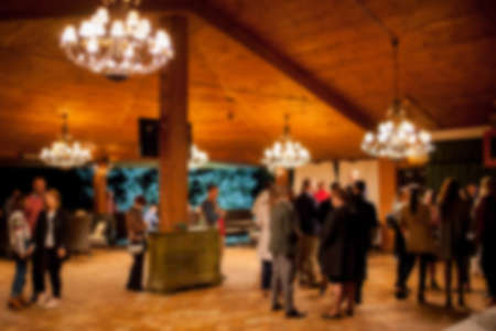 People rest in an ethnic, Mexican restaurant. Blurred photo. blur photo of restaurant with long table dinner and chair along it with bokeh light with yellow tone colorの写真素材