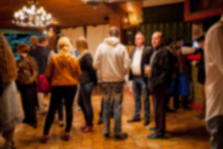People rest in an ethnic, Mexican restaurant. Blurred photo. blur photo of restaurant with long table dinner and chair along it with bokeh light with yellow tone colorの写真素材