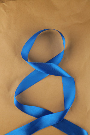 Satin ribbon in the form of number 8 blue on a light background. Top view, with copy space. 8 March...