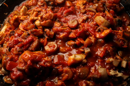 Vegetarian mushrooms chickpea stew in a iron pan on a dark background, top view. Healthy vegetarian food concept. Vegetable chiliの写真素材