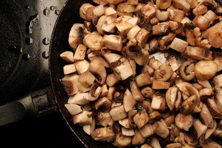 pieces of mushrooms in a pan. pieces of raw mushrooms in a pan. cooking raw mushroomsの写真素材