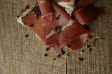 Sliced jamon on a wood background. Parma ham, jamon on wooden background with space for text top view. Jamon Serrano, Iberico. Traditional Spanish hamの写真素材