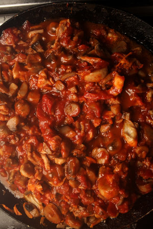 Vegetarian mushrooms chickpea stew in a iron pan on a dark background, top view. Healthy vegetarian food concept. Vegetable chiliの写真素材