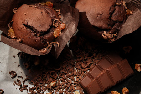 Cake of chocolate fondant cake, chocolate muffins with walnuts, raisins and grated chocolate, and dark chocolate bars on a dark black background. Perfect for creating a recipe book.の写真素材