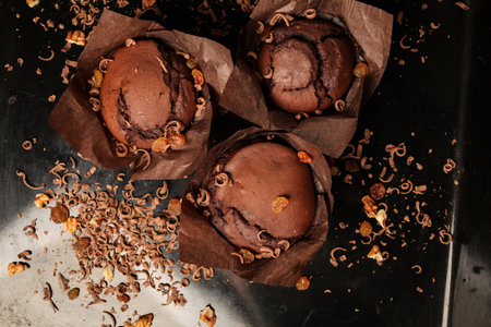 Cake of chocolate fondant cake, chocolate muffins with walnuts, raisins and grated chocolate, and dark chocolate bars on a dark black background. Perfect for creating a recipe book.の写真素材