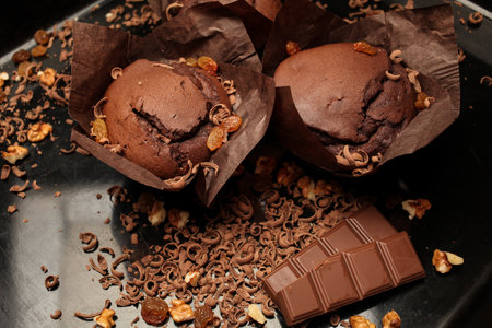 Cake of chocolate fondant cake, chocolate muffins with walnuts, raisins and grated chocolate, and dark chocolate bars on a dark black background. Perfect for creating a recipe book.の写真素材