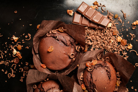 Cake of chocolate fondant cake, chocolate muffins with walnuts, raisins and grated chocolate, and dark chocolate bars on a dark black background. Perfect for creating a recipe book.の写真素材