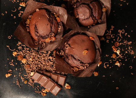 Cake of chocolate fondant cake, chocolate muffins with walnuts, raisins and grated chocolate, and dark chocolate bars on a dark black background. Perfect for creating a recipe book.の写真素材