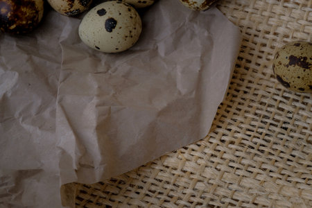 Easter quail eggs on craft paper and rustic burlap background. Easter eggs on craft paper and burlap fabric texture. Spring background with small easter quail eggs.の写真素材