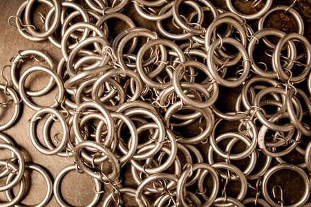 Metal rings, many metal rings, background. Metal chain of rings on a light background. Ring of steel rings, background of metallic shiny washersの写真素材