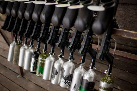 Paintball markers are on a stand. Paintball markers are standing on a wooden table. paintball gun should standの写真素材