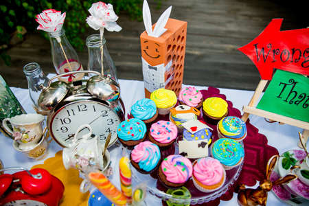 Holiday themed table for the tea ceremony. Table with sweets. Tea with sweets. Table of Alice in Wonderlandの写真素材