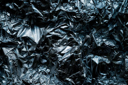 Aluminum crumpled foil texture background. Part of wrapping paper for gifts. Aluminum foil with a violet blue coloring traces. Metal crumpled paper shabby and dust. Decorative background concept.の写真素材