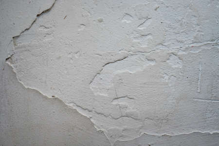 Crack. Texture of old painted white plaster. Cracked wall. white wall with cracks. Old white cracked paint backgroundの写真素材