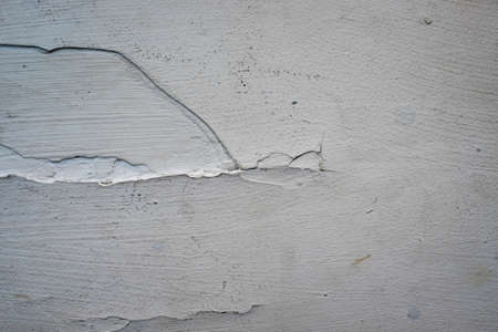 Crack. Texture of old painted white plaster. Cracked wall. white wall with cracks. Old white cracked paint backgroundの写真素材