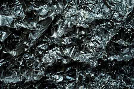 Aluminum crumpled foil texture background. Part of wrapping paper for gifts. Aluminum foil with a...