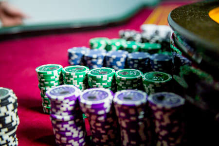 Casino chips colorful gaming pieces lie on the game table in the stack. Background for gamblingの写真素材