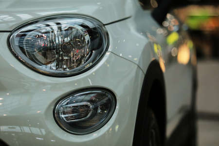 Headlights, white car. headlights of a new white car on a bokeh background.の写真素材