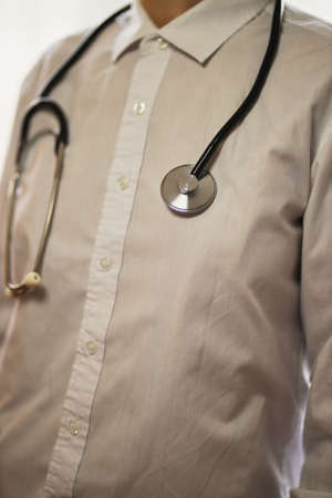 doctor with a stethoscope on hospital background. A doctor in a white coat with a stethoscope.  treatment. A doctor in a white coat holds a stethoscope in his hands. Healthcare concept.の写真素材