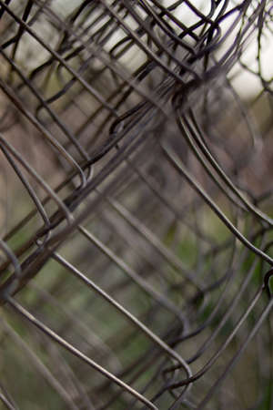 Twisted mesh. welded wire mesh twisted into a roll background. fence stretched mesh background. mesh close-up photoの写真素材