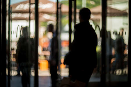 Blurred silhouettes of people in the business center. lobby in the rush hour is made in the manner of blur. silhouettes of people as they move, for the blurred background.の写真素材