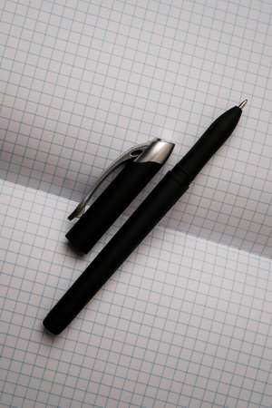 Open the notebook in a cage on a wooden table with a handle. Open the laptop on your desktop. Open notebook, diary with pen. Close-up photo. Business concept, place for textの写真素材