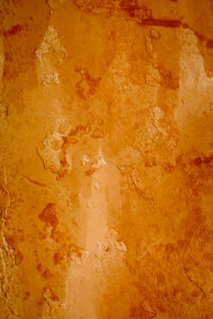 Bright grunge wall texture. Grunge vintage stone wall background texture with orange texture of husk, stain paint. Vintage orange wall wallpaper. Texture wall, orange grunge background, stain.の写真素材