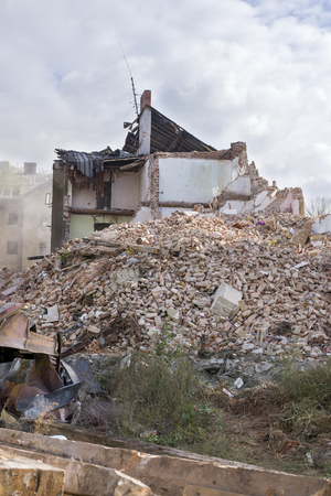 Half collapsed brick house covered in dust and debris.の写真素材